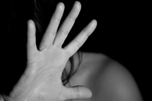 Frau hält ihre Hand schützend vor ihr Gesicht